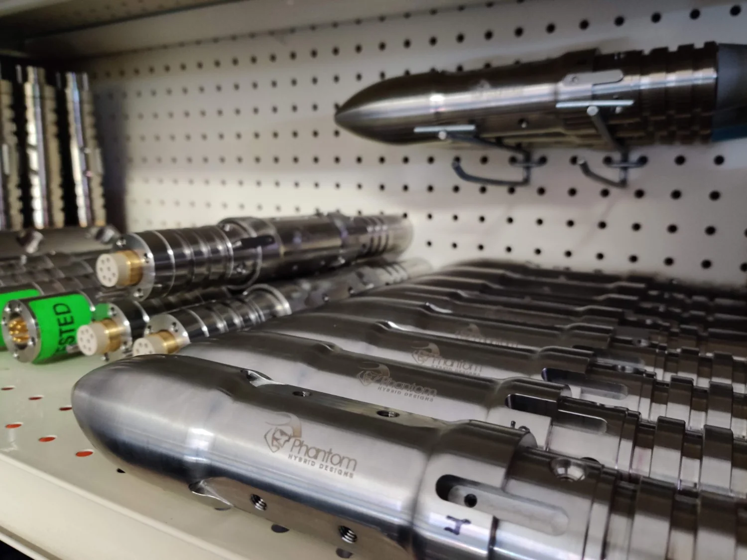 PHD-branded metal components displayed on a shop pegboard